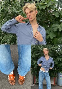 Mladý člověk ve pruhovaném tričku a světle modrých džínách pózuje venku v blízkosti zeleného listoví, na nohou má tenisky Adidas s leopardím vzorem a oranžovými tkaničkami.