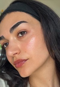Profiel van een persoon met een gemiddelde huidskleur, donker haar, gedefinieerde wenkbrauwen en glanzende lippen. Licht verlichte huid met subtiele textuur.
