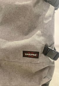 Zweifarbiger Stoffrucksack mit strukturierter Oberfläche, ausgestattet mit einem schwarzen EASTPAK-Logo und einem Plastikverschluss zum Schließen.