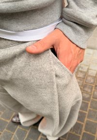 Harmaa collegepaita resorihihoilla ja -helmalla, yhdistetty harmaisiin housuihin, joissa on sivutasku ja pehmeä materiaali.