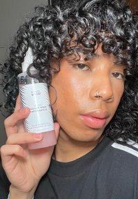 Spray teksturowe Bondi Boost Sea Salt w przezroczystej butelce z różowym dnem. Ma czarno-białe geometryczne wzory oraz rozpylacz.