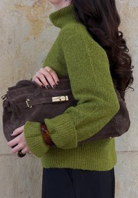 Grøn strikket turtleneck sweater med ribbede manchetter, parret med en brun ruskinds håndtaske med guldfittings og en struktureret overflade.