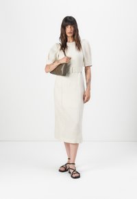 Cremefarbnes Leinen-Midi-Kleid mit Puffärmel, tailliertem Gürtel und einem braunen, gesteppte Handtasche sowie schwarzen Riemchensandalen.