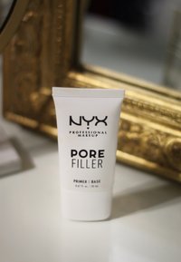 Primer NYX Pore Filler in einer weißen 20-ml-Tube. Mit fettem schwarzen Text und einer glatten, matten Oberfläche. Entwickelt für einen porenverblassenden Effekt.