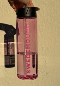 Bottiglia d'acqua trasparente rosa con tappo e cannuccia nera; presenta un logo "SWEDEMOUNT" ben visibile sul lato.