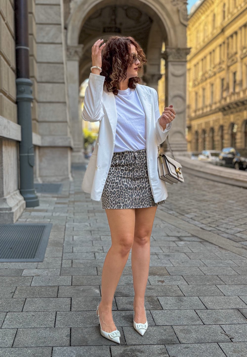 Vit kavaj över en enkel vit t-shirt, i kombination med en leopardmönstrad kjol. Avslutat med vita stilettklackar och en liten handväska.