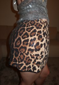 Leopárdmintás rövidnadrág bézs és fekete színekben, szegecsekkel díszített texturált anyagból, bővülő szegéllyel, testhezálló megjelenésre tervezve.