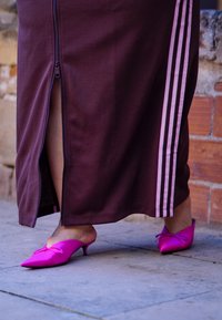 Καφέ αθλητική φούστα με φερμουάρ και ροζ ρίγες, συνδυασμένη με φωτεινές ροζ μπαλαρίνες με尖ास्त πίσω και φιόγκο.