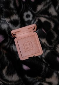 Kompakt blush i myk rosa casing med en glitrende, lys ferskenfarge innside. Har preget merkevarelogo på puderytelsen.