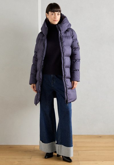 Abrigo acolchado morado con capucha, que presenta una textura brillante, bolsillos con cremallera y un diseño entallado, combinado con unos pantalones de mezclilla de pierna ancha.