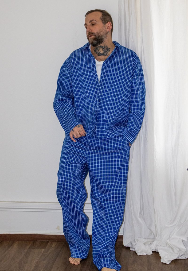 Ensemble de pyjama à carreaux bleus en coton, comprenant une chemise à manches longues boutonnée et un pantalon ample avec une silhouette décontractée.