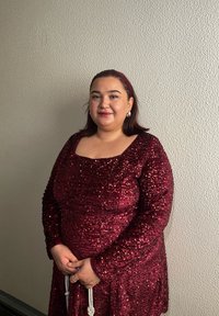 Robe bordeaux à sequins avec manches longues, encolure ronde, et coupe ajustée. Accessoires incluent un bandeau avec bijoux et un bracelet.