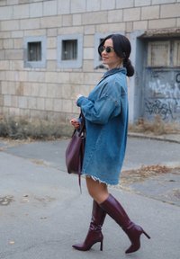 Oversize džinsa jaka ar saplēstu apakšu, kombinēta ar ce�ļgalu augstiem vīnsarkanajiem zābakiem un saskaņotu rokassomiņu. Ietver melnas apaļas saulesbrilles.