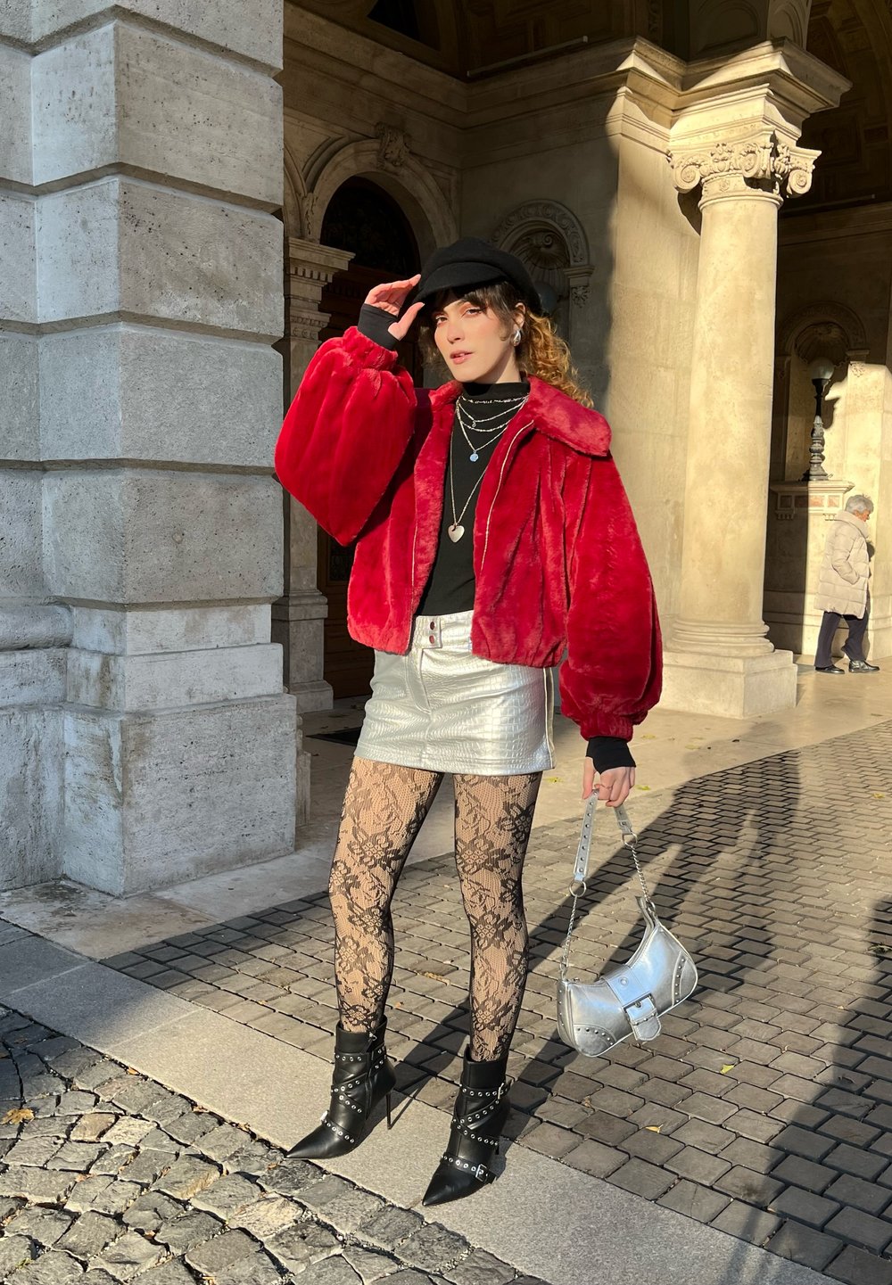 Rød faux fur-jakke med svart topp, sølvmetallic mini skjørt, sorte blonde strømpebukser og svarte naglede ankelstøvler. Sølvhåndveske.