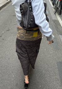 Cargoskirt met camouflagedessin, een bruine onderkant en een olijfgroene taille. Gecombineerd met een zwarte leren tas en zwarte schoenen.