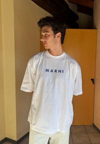 T-shirt oversized branca apresentando "MARNI" em azul na parte da frente. Feito de algodão macio, com decote redondo e manga curta.