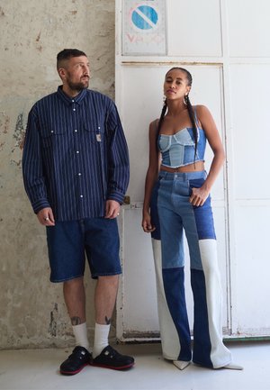 Striped navy shirt, denim shorts, paired with a blue denim cropped top and patched wide-leg pants. White and blue accents, casual footwear.