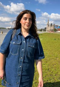 Robe-en-jean à manches courtes, avec deux poches avant et des boutons argentés. Présente une coupe décontractée et une longueur mi-thigh dans une couleur bleu foncé.