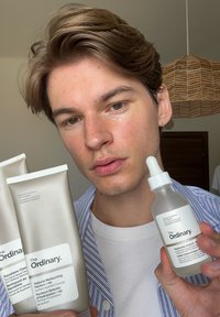 Prodotti per la cura della pelle di The Ordinary: due tubetti di crema con etichette beige chiaro e un flacone con pipetta e tappo bianco, tutti con un design minimalista.