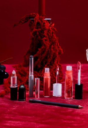 Osiem produktów do ust na czerwonej powierzchni: matowa nudowa pomadka, trzy płynne pomadki w przezroczystych i kolorowych tubkach oraz konturówka do ust.