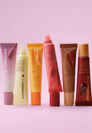 Six tubes de traitement pour les lèvres OLEHENRIKSEN Pout Preserve Peptide dans des couleurs pastel et vives, chacun avec un échantillon de produit pour les lèvres sur le côté.