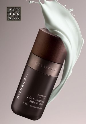 Rituals homme 24h hydrating face cream bottle with wooden cap, splashing white cream fluid on beige background.