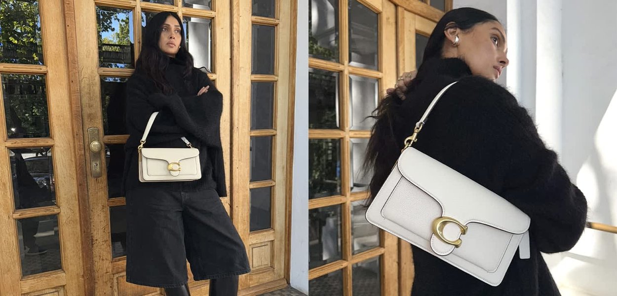 Weiße Lederhandtasche mit einem goldenen, runden Verschluss, die über eine glatte Oberfläche, rechteckige Form und einen abnehmbaren Schultergurt verfügt.