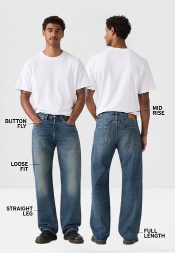 Hombre con camiseta blanca y vaqueros azules de ajuste holgado, talle medio y cierre de botones, mostrados de frente y de espaldas con detalles de pierna recta y longitud completa.