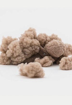 Hellbraunes, flauschiges Material, das texturierten Puffs ähnelt und in unterschiedlichen Größen verstreut ist. Einige sind dicht, während andere lockerer und luftiger wirken.