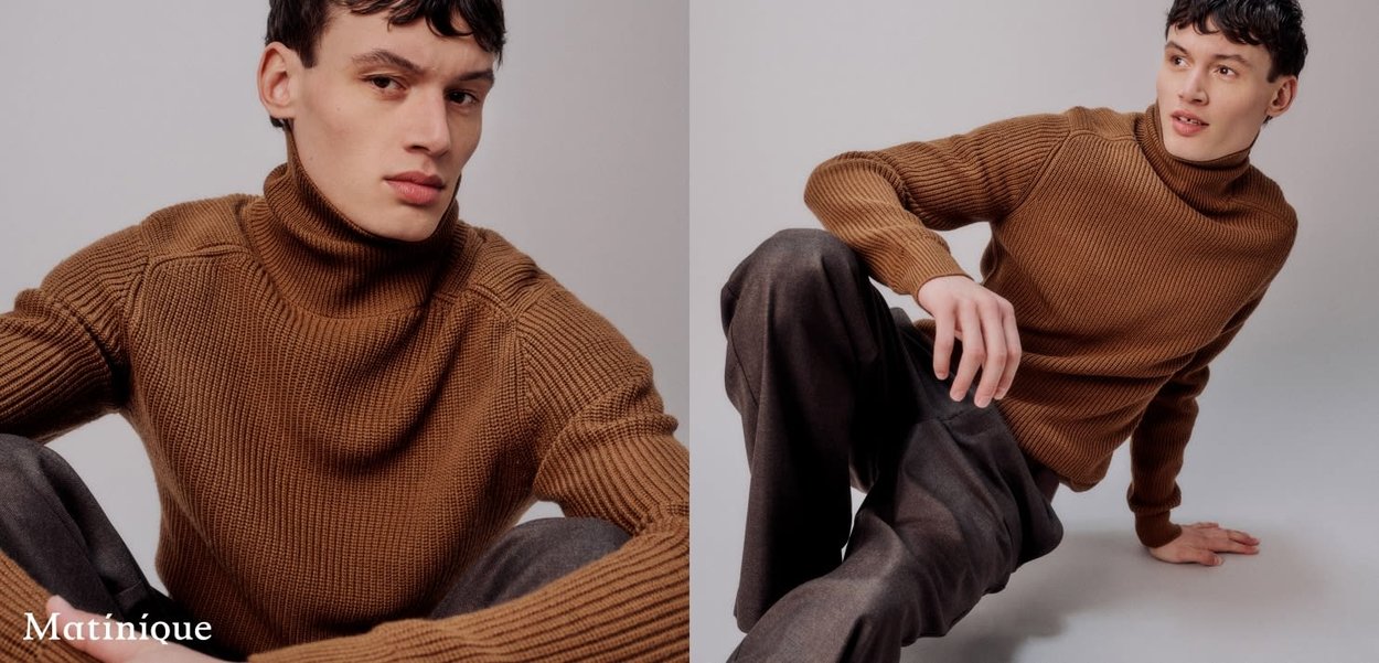 Brauner gerippter Rollkragenpullover mit hohem Kragen, strukturiertem Oberflächenmaterial und taillierten Ärmeln, kombiniert mit dunkelgrauen Hosen.