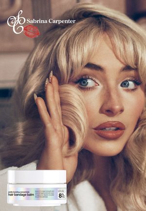 Blonde vrouw raakt een gekrulde haarlok aan; pot haarbandagebalsem getoond; "Sabrina Carpenter" en logo verschijnen linksboven.