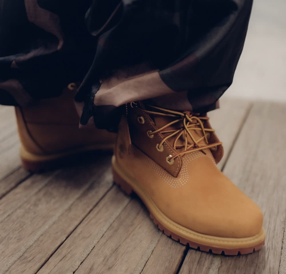 Gelbe Lederstiefeletten mit runder Zehenpartie, Schnürung vorne und gepolstertem Kragen. Strukturiertes Design und eine Gummisohle für besseren Halt.