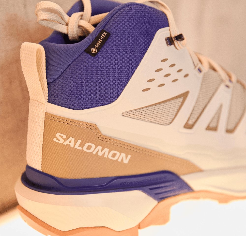 Salomon hiking shoe with a breathable blue mesh upper, cream and beige accents, textured sides, and a flexible gum rubber sole.