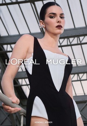 Sort og hvid ærmeløs bodysuit med vinklede udskæringer og en tætsiddende pasform. Modellen har tilføjet en stor ørestik og poserede i en trappeopgang.