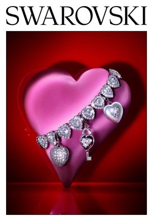 Armband met hartvormige kristallen bedels en een sleutelbedel, tentoongesteld op een roze hart tegen een rode achtergrond, met het Swarovski-logo erboven.