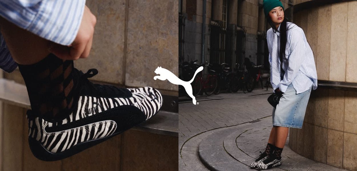 Sorte og hvite zebra-stripete sneakers med teksturert overflate, parret med svarte fiskenett-sokker og et denim-skjørt.