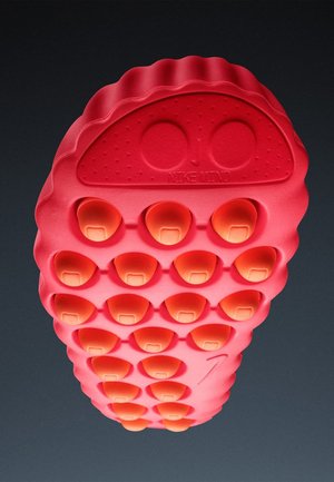 Czerwona gumowa podeszwa buta z zaokrąglonymi, fakturowanymi wypustkami i pomarańczowymi akcentami. Projekt zawiera wypukłe logo i faliste krawędzie.