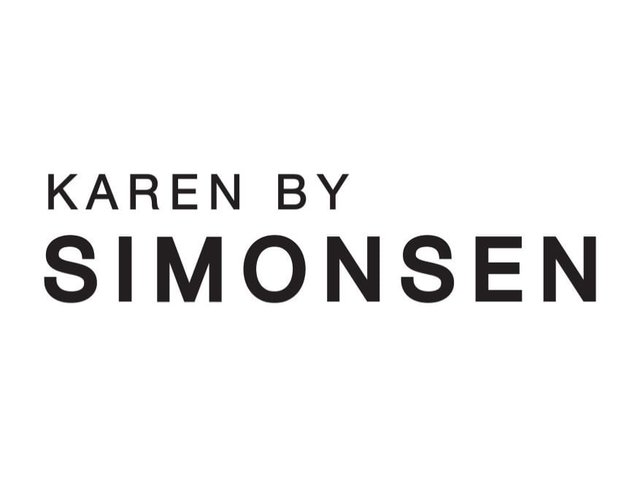 Du texte noir indique "KAREN BY SIMONSEN" sur un fond blanc. La police est géométrique, sans empattement, avec des largeurs de lettres variées.