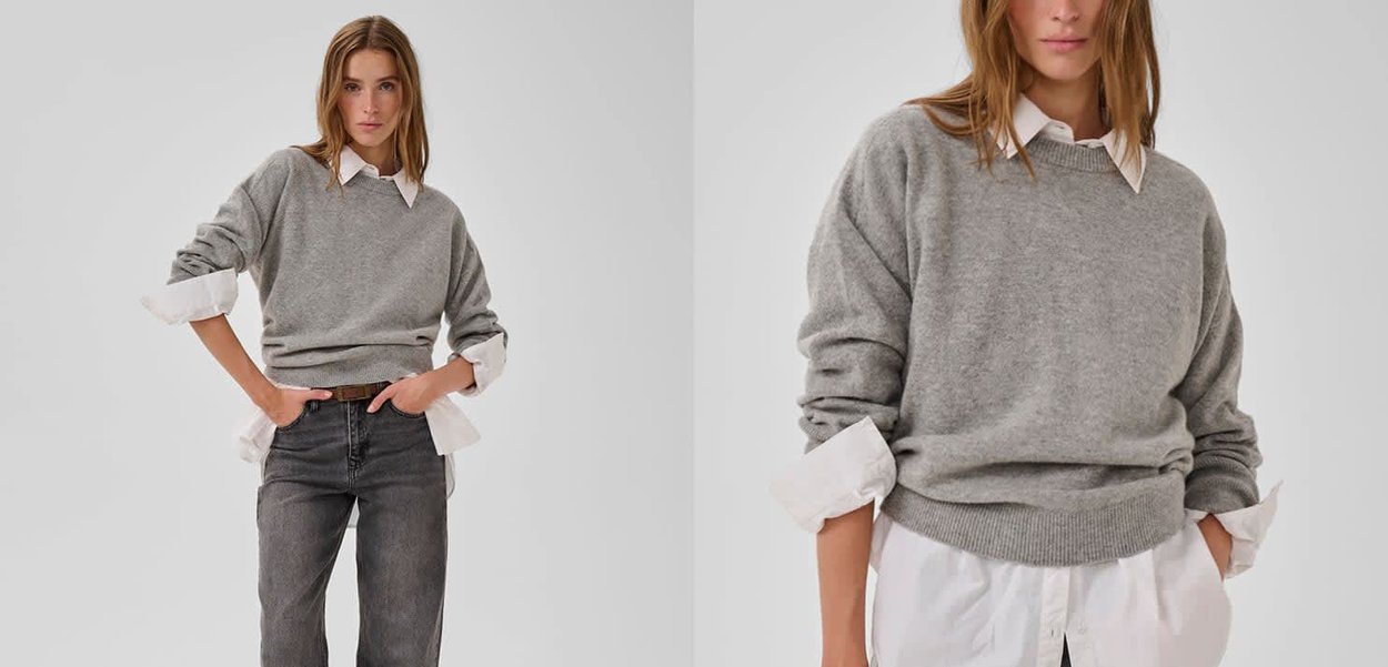 Grauer Strickpullover über einem weißen Hemd, mit gerippten Bündchen und Saum, lässige Passform, getragen mit hochtaillierten dunklen Jeans.