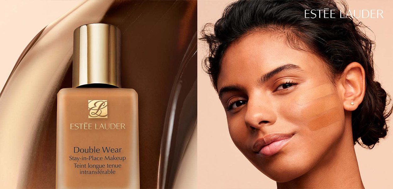 Estée Lauder Foundationflasche neben einem Modell, das drei Farbproben auf ihrer Wange zeigt, die verschiedene Farbnuancen darstellen.