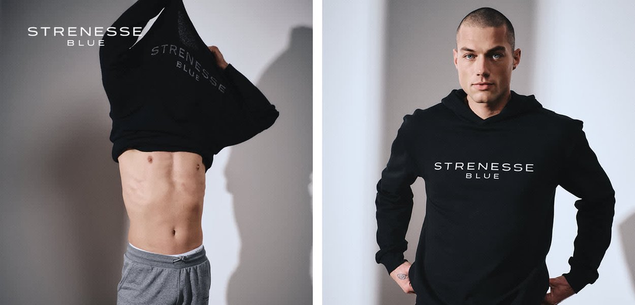 Männliches Model zieht schwarzen "Strenesse Blue" Hoodie über den Kopf und zeigt definierte Bauchmuskeln; zweite Ansicht zeigt ihn, wie er den Hoodie trägt und nach vorne blickt.