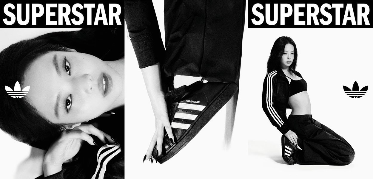 Black Adidas Superstar sneakers with white stripes, logo, and textured surface; a model wears black athletic wear in a monochrome setting.