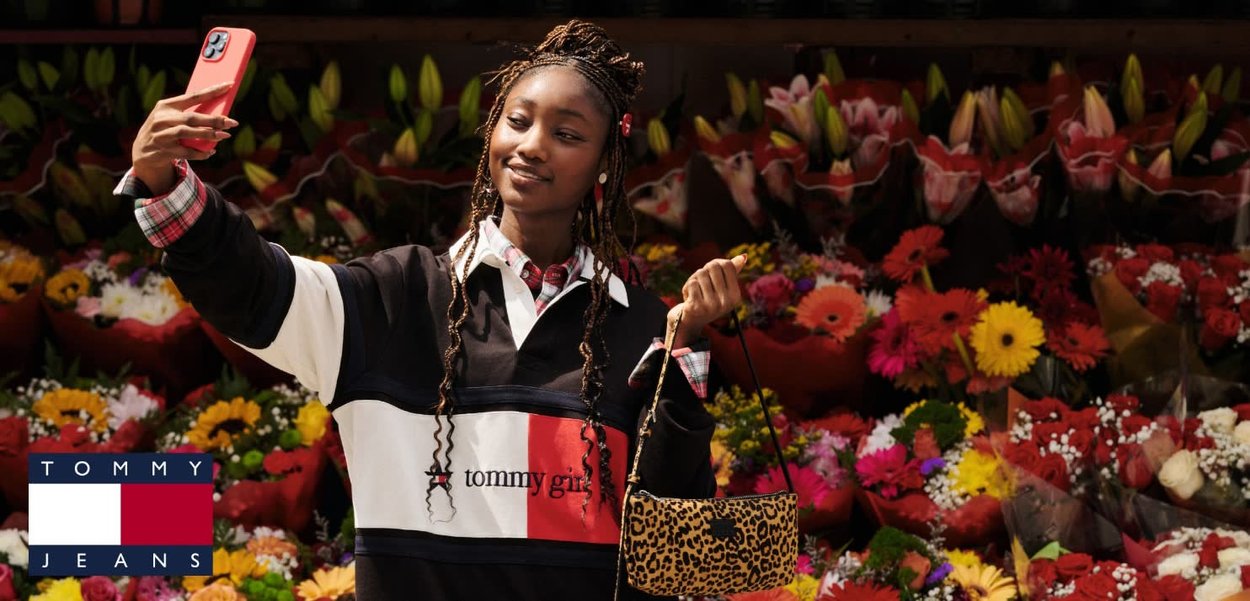 Sudadera en color bloqueado en blanco y negro con un acento rojo, bolso de estampado de leopardo y cuello de camisa a cuadros; fondo floral.