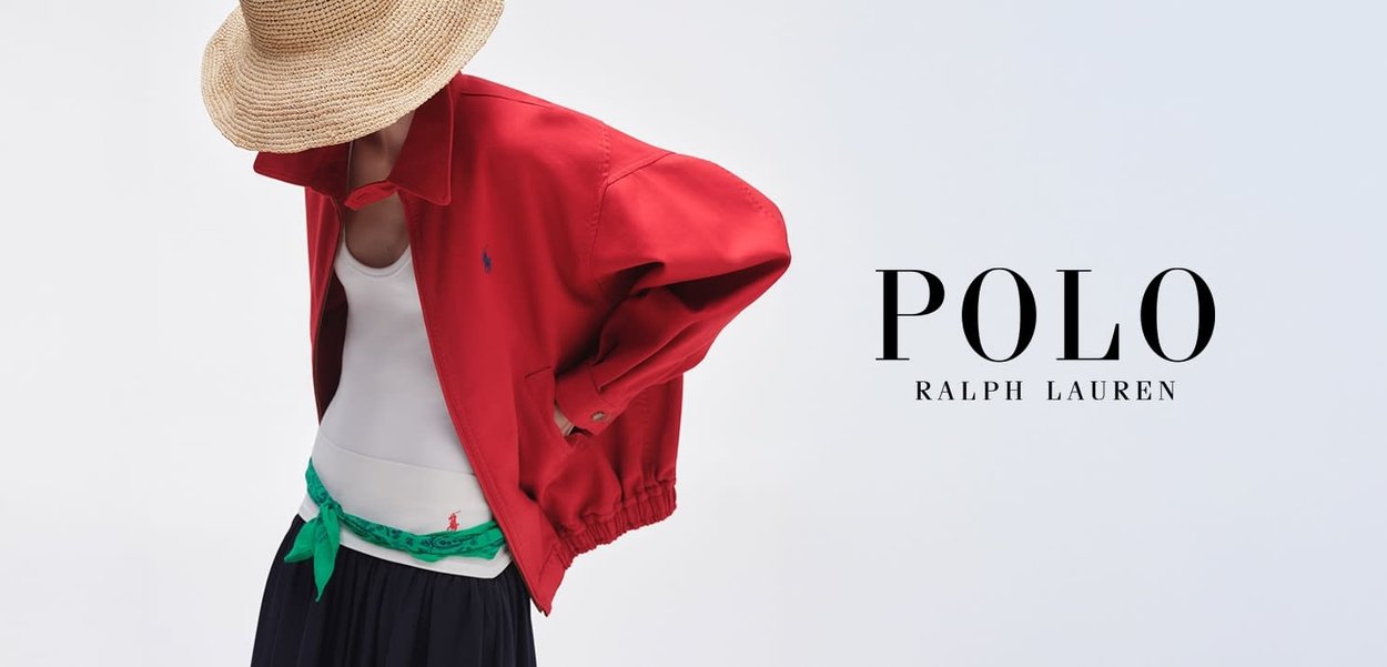 Persona con chaqueta roja, camiseta blanca, cinturón verde, falda negra y sombrero de paja mirando hacia abajo con el logo de Polo Ralph Lauren sobre fondo blanco.