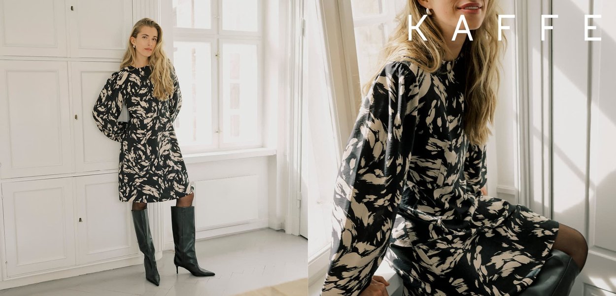 Robe à motif noir et crème avec manches longues bouffantes et taille cintrée, associée à des bottes noires montantes jusqu'aux genoux. Silhouette élégante.