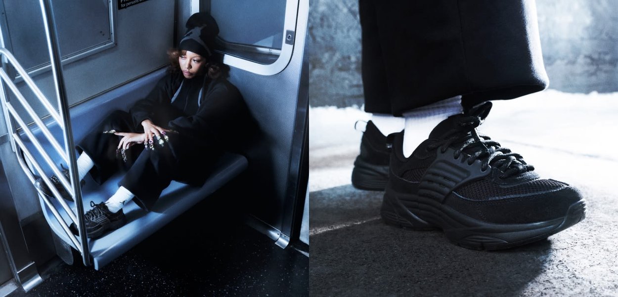 Personne portant des vêtements noirs et des baskets noires avec des chaussettes blanches assise sur un siège de métro à l'intérieur d'une rame de train.