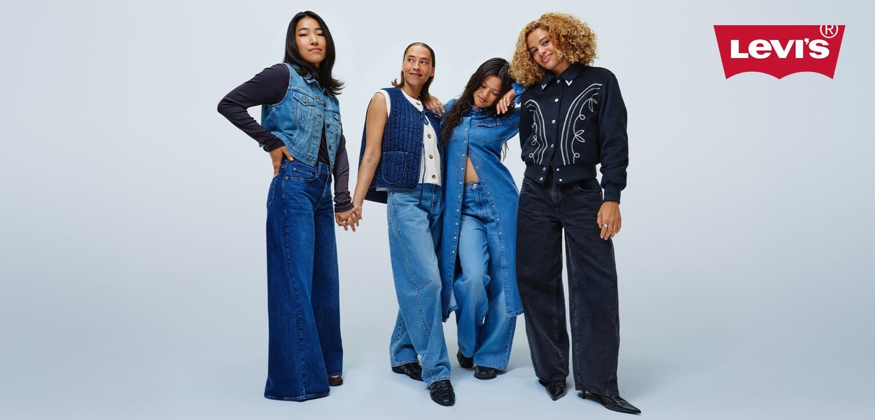 Gruppe på fire modeller som har på seg ulike denimantrekk: vester, jakker og vide jeans i nyanser av blått og svart, som viser forskjellige teksturer og stiler.