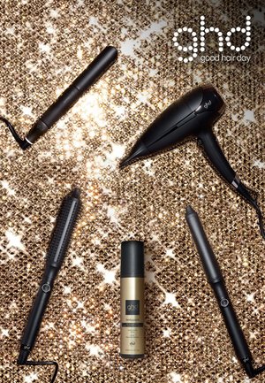 Outils de coiffure noirs disposés sur un fond doré et scintillant. Comprend un sèche-cheveux, un fer à lisser, un fer à boucler et un vaporisateur.