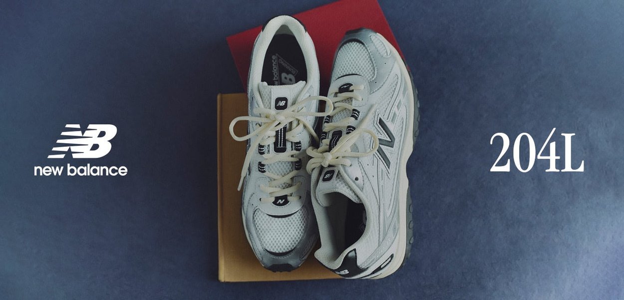 Sneaker bianche in mesh con accenti grigi e loghi neri. I lacci sono allacciati, evidenziando una linguetta imbottita e suole ammortizzate. Modello 204L notato.