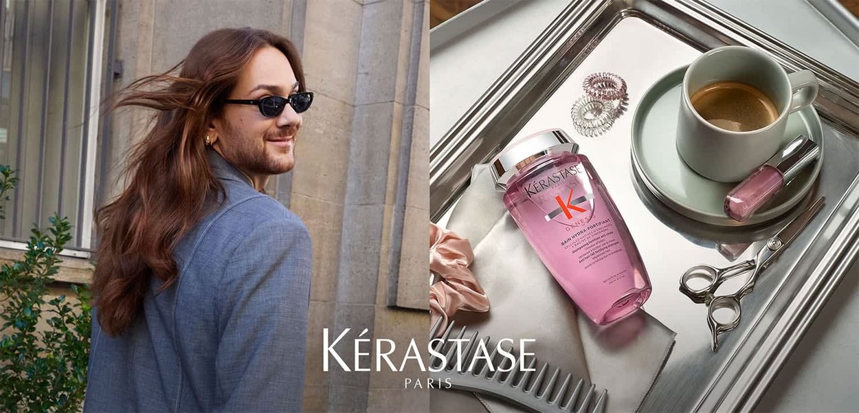 Kérastase Shampoo-Flasche in Pink mit einem silbernen Deckel, daneben eine weiße Kaffeetasse, Nagellack, Scheren und Haaraccessoires auf einem Tablett.